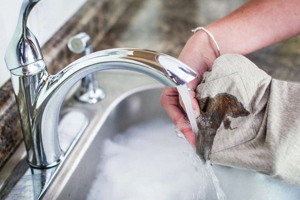 Washing a stain out of t-shirt in the kitchen sink