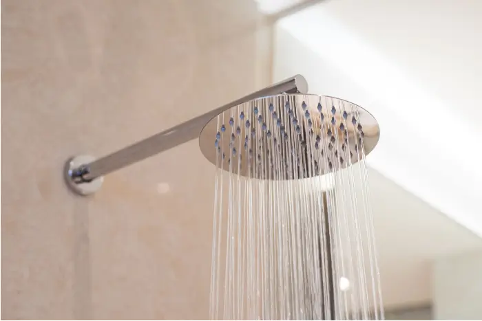 Shower head running in a bathroom