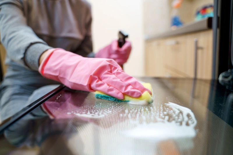 Person cleaning the glass inside an oven door.