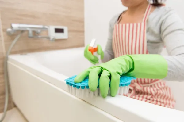 Woman deep cleaning bathroom tub