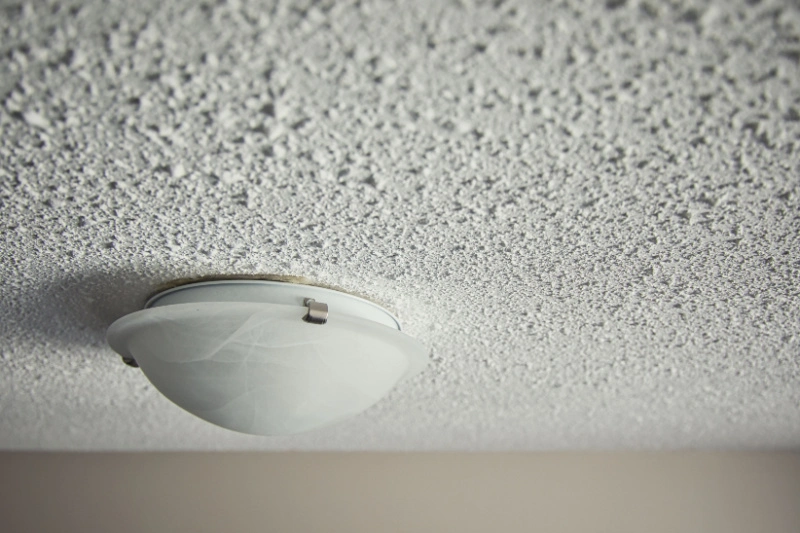 Popcorn ceiling with lighting fixture.