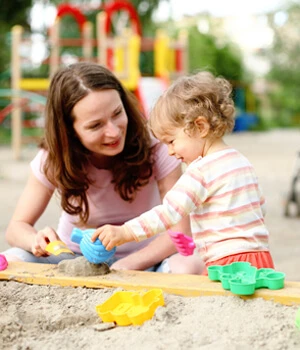 mom and child playing in the sand