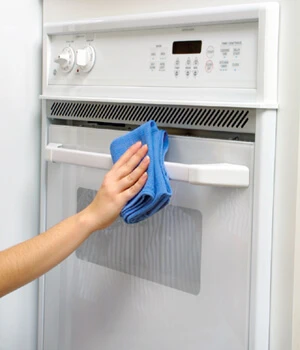 Molly Maid team member cleaning an oven