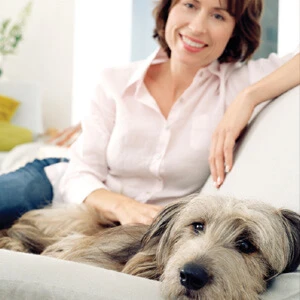 Woman sitting on couch with her dog