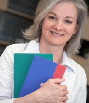 woman smiling holding a notebook