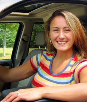 woman smiling looking out a car window