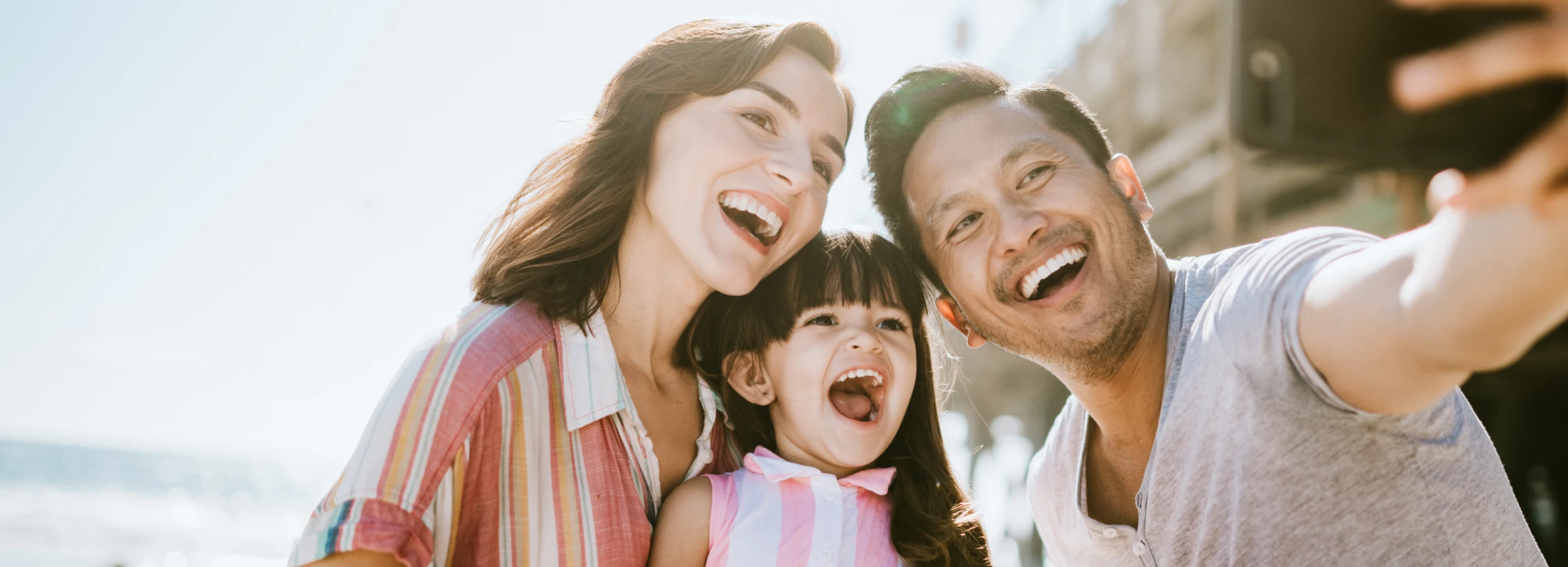 Smiling family taking a selfie with their cell phone.