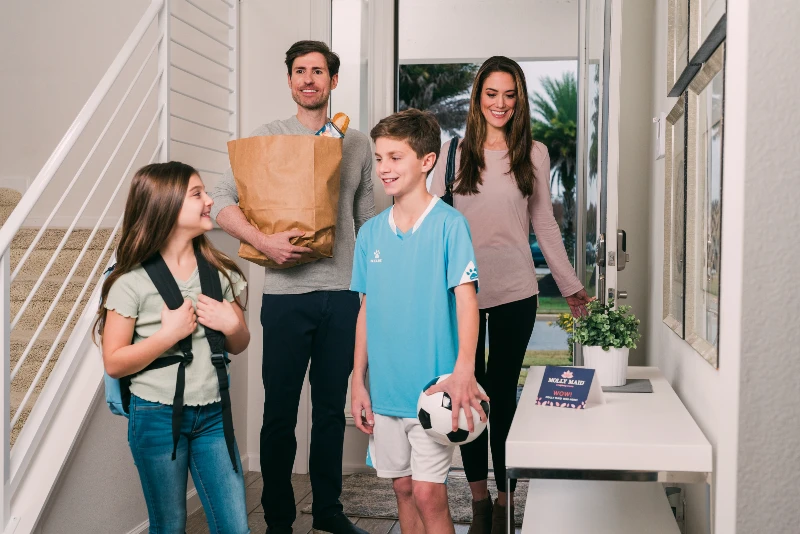 Family coming home standing in the entryway.