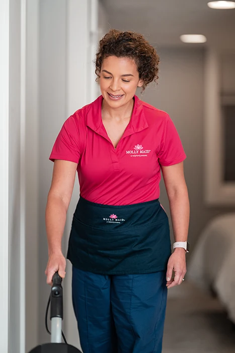 A Molly Maid professional vacuuming during a condo cleaning appointment. 