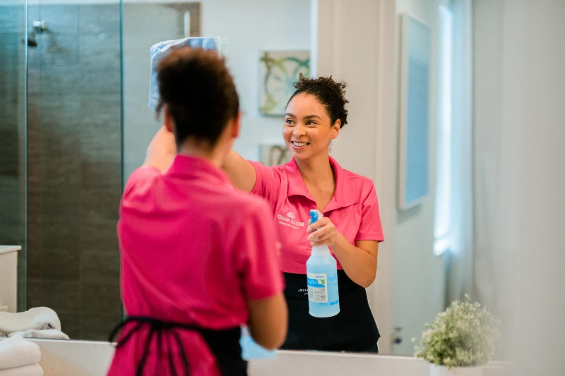 Molly Maid employee cleaning a bathroom mirror